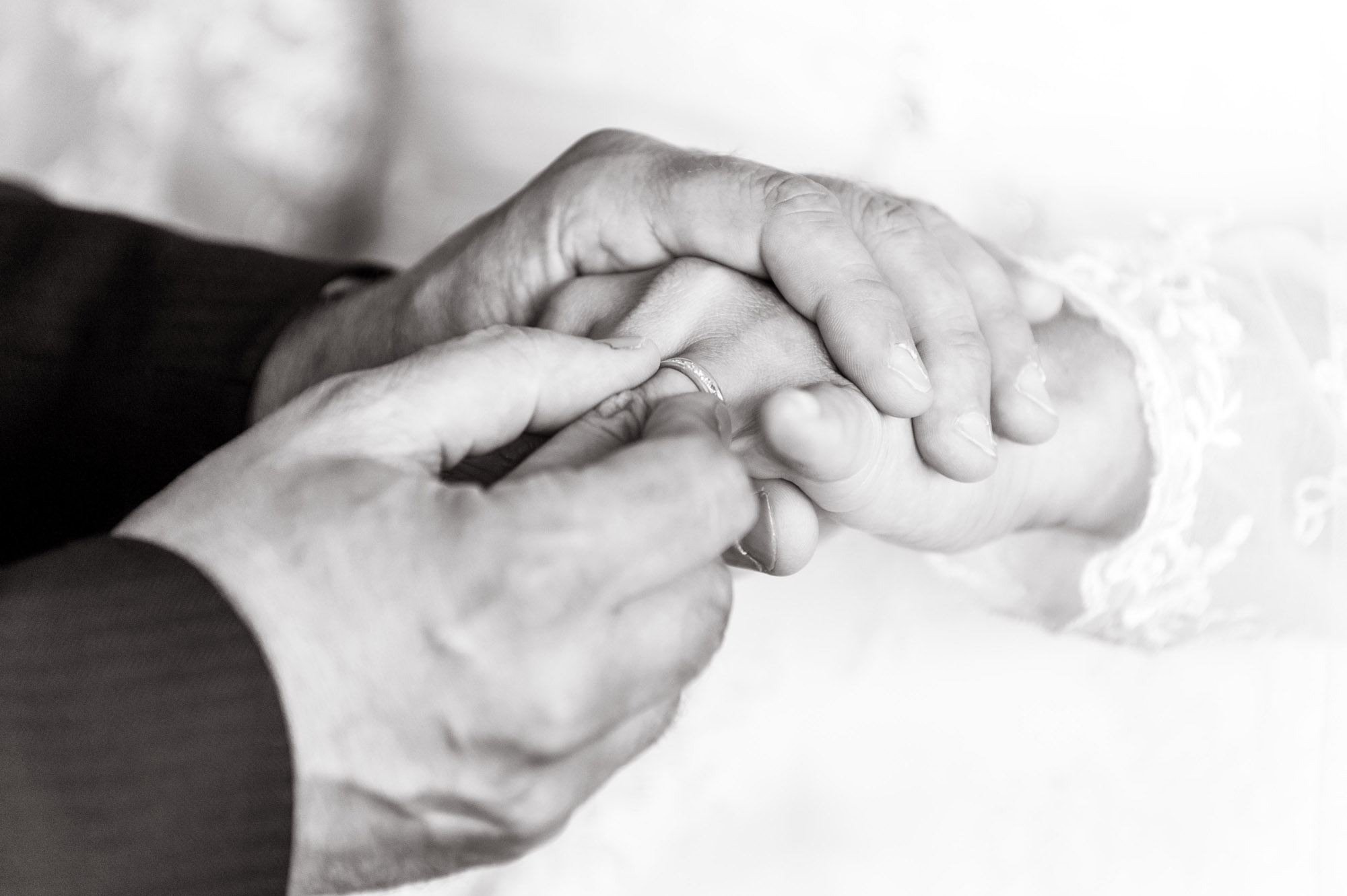 Close up photograph of a couple exchanging rings during their wedding ceremony taken by wedding photographer Richard Eaton.