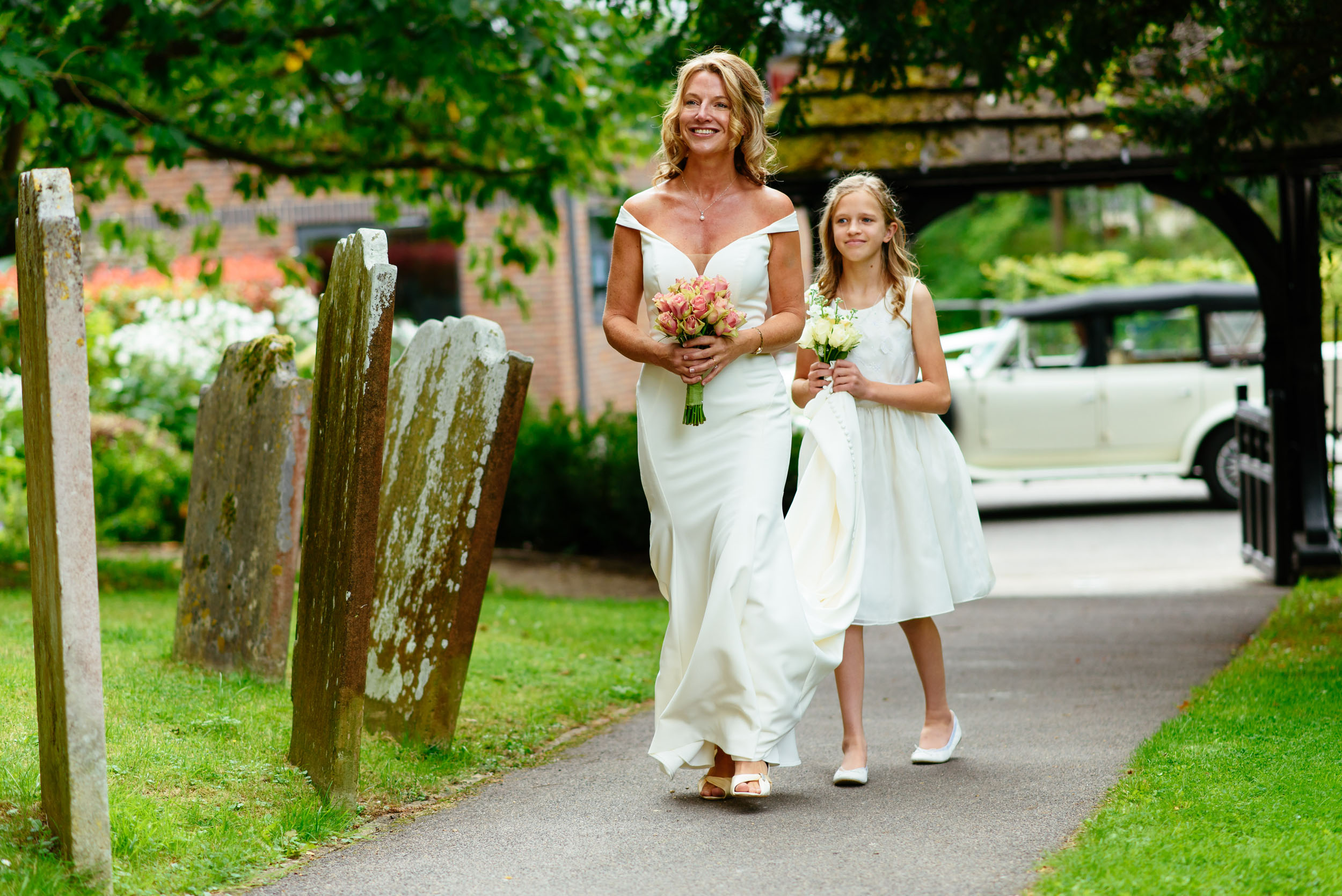Bride and bridesmaid arrive at the church on the day of her wedding taken by Surrey based wedding photographer Richard Eaton. 