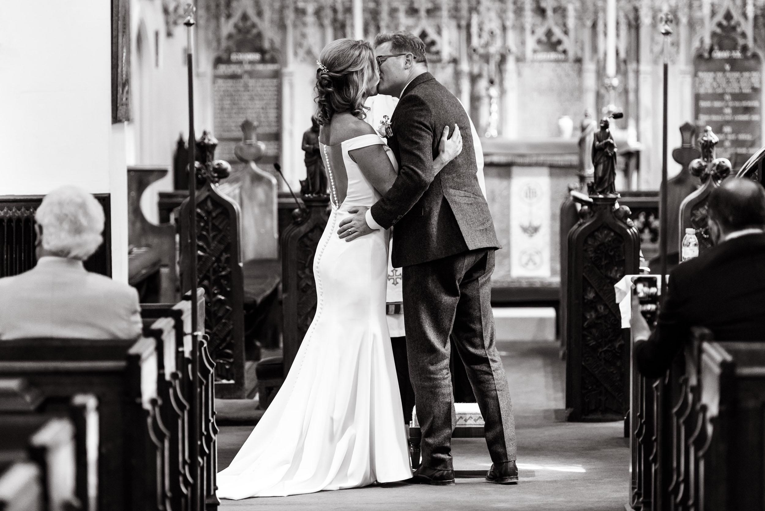 Black and white photograph of a couple kissing during their wedding ceremony taken by wedding photographer Richard Eaton.