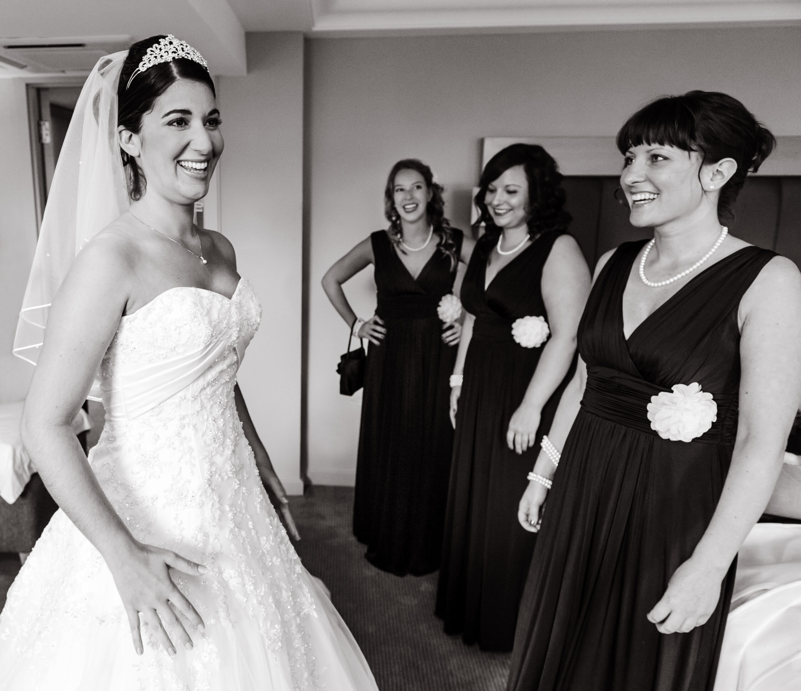 Bride getting ready on her wedding day with the help of her bridesmaids taken by Surrey based wedding photographer Richard Eaton. 